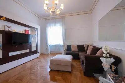 a living room with a couch and a television at Lucrezio Caro Luxury Apartment in Rome