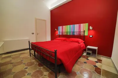 a red bedroom with a bed with a colorful wall at P88 guesthouse in Rome