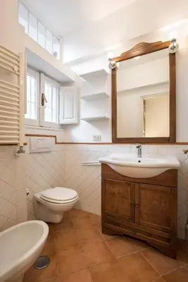 a bathroom with a sink toilet and a mirror at Eri's Apartment in Rome