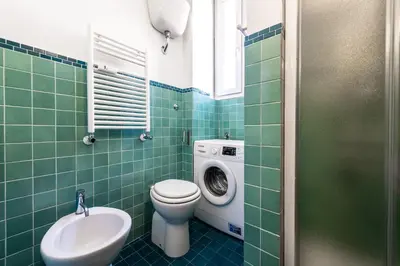 a bathroom with a toilet and a washing machine at Casa Nica in Rome