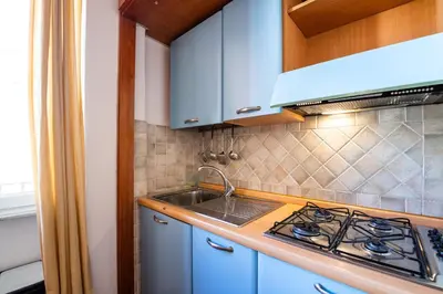 a kitchen with blue cabinets and a stove and a sink at Casa Nica in Rome