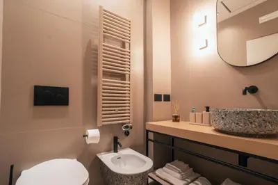 a bathroom with a toilet and a sink and a mirror at The Flow - Via Del Corso in Rome