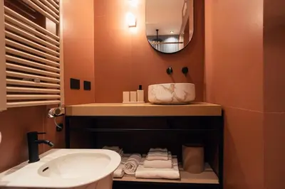 a bathroom with a sink and a mirror and towels at The Flow - Via Del Corso in Rome