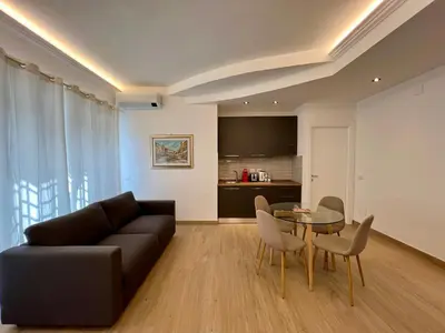 a living room with a couch and a table and a kitchen at Trastevere Tre Porte Apartments in Rome