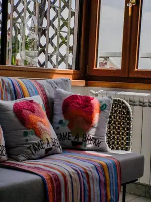 a couch with a bird pillow on it at Chic and Spacious Rome Penthouse in Rome