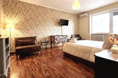 a bedroom with a bed and a chair and a television at 129 Gallery’s Studio @ Vatican in Rome