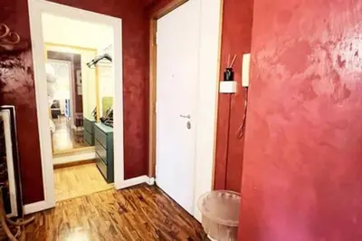 a room with a bathroom with a red wall at 129 Gallery’s Studio @ Vatican in Rome