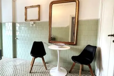 a bathroom with two black chairs and a mirror at 129 Gallery’s Studio @ Vatican in Rome