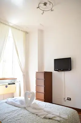 a bedroom with a bed with a tv on the wall at Casa Vacanze Mazzini in Rome