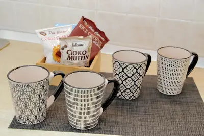 four black and white coffee cups sitting on a counter at FleminHouse a soli 10 min da San Pietro in Rome
