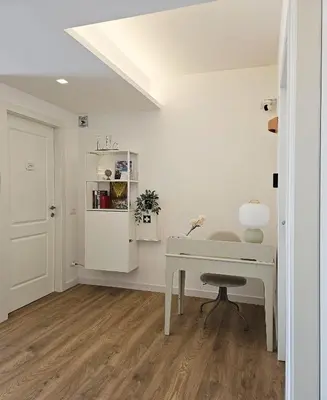 a white desk in a room with a white wall at B&B Domus Teano Luxury Rooms in Rome