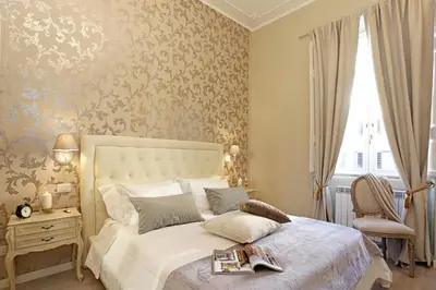 a bedroom with a bed and a chair and a window at Liberty Rome Suites - Liberty Collection in Rome