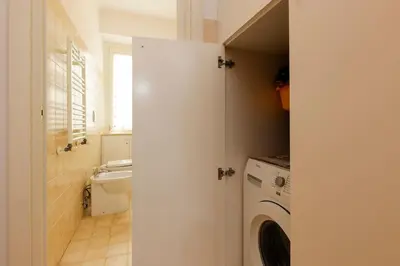 a bathroom with a toilet and a washing machine at Delizioso apartment Porta Metronia Roma in Rome