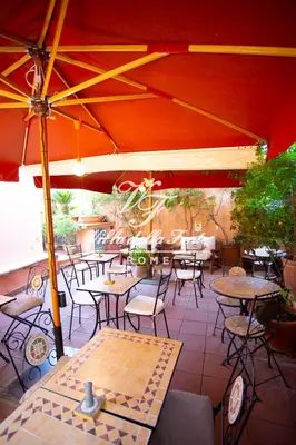 a patio with tables and chairs and an umbrella at Villa della Fonte in Rome