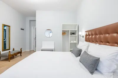 a bedroom with a large white bed with a brown headboard at Domus Bella Roma in Rome