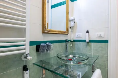 a bathroom with a glass sink and a mirror at Domus Bella Roma in Rome