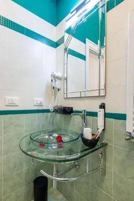 a glass sink in a bathroom with a mirror at Domus Bella Roma in Rome