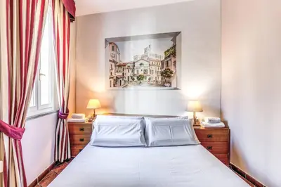 a bedroom with a bed and a painting on the wall at Cozy flat in Trevi Fountain in Rome
