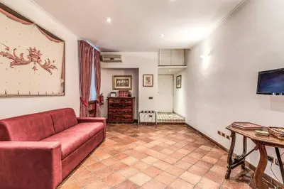 a living room with a red couch and a tv at Cozy flat in Trevi Fountain in Rome