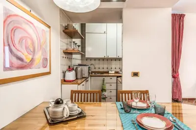 a kitchen and dining room with a table and chairs at Cozy flat in Trevi Fountain in Rome