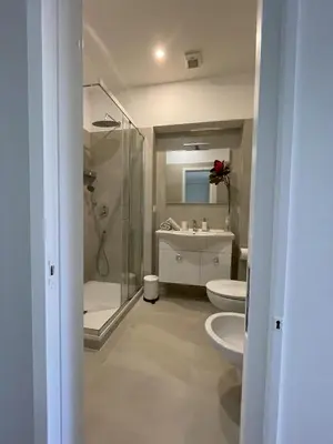 a bathroom with two toilets and a shower and a sink at Maresi Suite in Rome