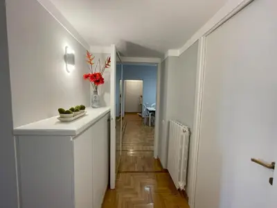 a white kitchen with a vase of flowers on a counter at Maresi Suite in Rome