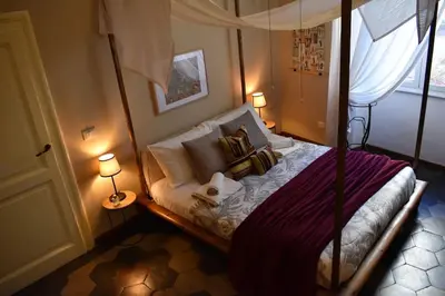 a bedroom with a canopy bed with two lamps at BOUTIQUE TRASTEVERE in Rome
