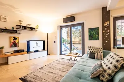 a living room with a blue couch and a tv at Ædrian's Loft. Boutique apartment with private terrace in the center of Rome in Rome