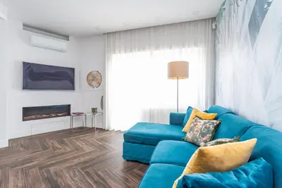a blue couch in a living room with a fireplace at Gregory 7House Vaticano in Rome