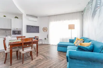a living room with a blue couch and a table at Gregory 7House Vaticano in Rome