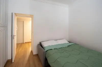 a bedroom with a bed in a white room at Casa M.O.R.E. in Rome