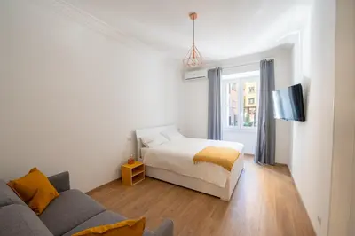 a white bedroom with a bed and a couch at Casa M.O.R.E. in Rome