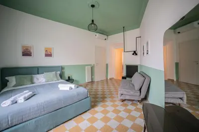 a bedroom with a bed and a chair and a television at Vintage Giuliana Apartment in Rome