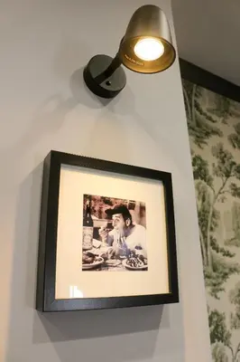 a picture hanging on a wall with a light at FLOWER HOUSE in Rome