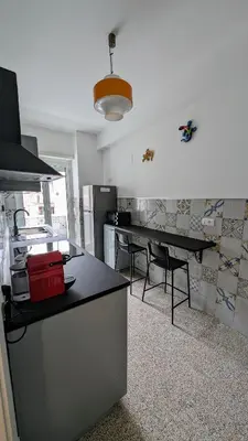 a kitchen with a counter and a table with chairs at A casa nostra - Musei Vaticani in Rome