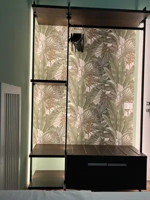 a bedroom with a wall with a floral wallpaper at Colosseum Deluxe in Rome