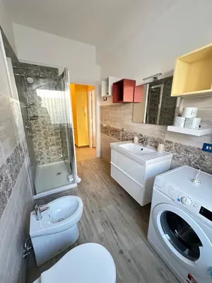 a bathroom with a toilet a sink and a washing machine at Il Giardino a Monte Sacro in Rome