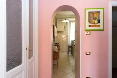 a hallway with a pink wall and an archway at Boezio House in Rome