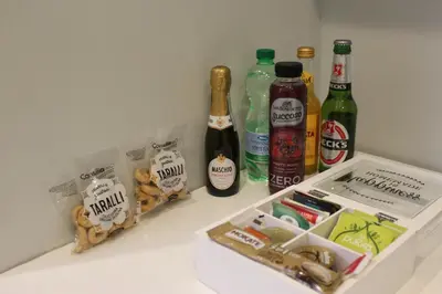 a refrigerator with bottles of alcohol and snacks at Argilla House 10 min a piedi dal Vaticano in Rome