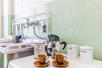 a kitchen counter with cups and a coffee maker at Retro design flat near Vaticano in Rome