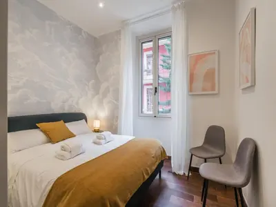 a bedroom with a bed with two chairs and a window at The Best Rent -Cozy two bedroom apartment near Vatican City in Rome