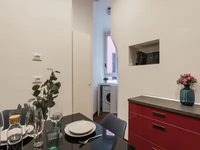 a kitchen with a dining table and a red cabinet at The Best Rent -Cozy two bedroom apartment near Vatican City in Rome