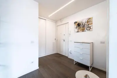 a bedroom with white walls and wood floors and a dresser at Time 4 Rome in Rome