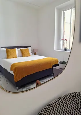 a bedroom with a bed with a mirror on the wall at Romantic Suite Colosseum - Luxury Apartment in Rome