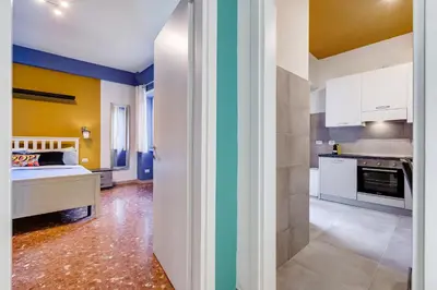 a kitchen with yellow and blue walls and a bed at BDC - The Perfect Mix in Rome