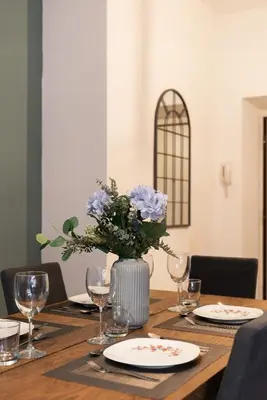 a wooden table with a vase with blue flowers on it at Piacentino Homes Re di Roma apartment in Rome