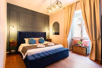 a bedroom with a large bed with a blue headboard at Piacentino Homes Re di Roma apartment in Rome