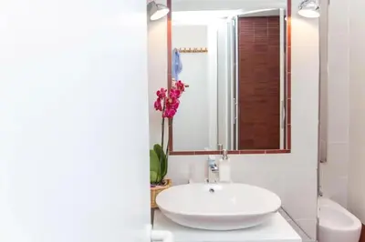 a white bathroom with a sink and a mirror at Perla - Cozy Apartment in Piazza Navona in Rome