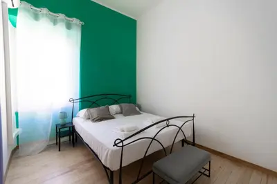 a bedroom with a bed and a green wall at Trastevere four seasons Feltre in Rome