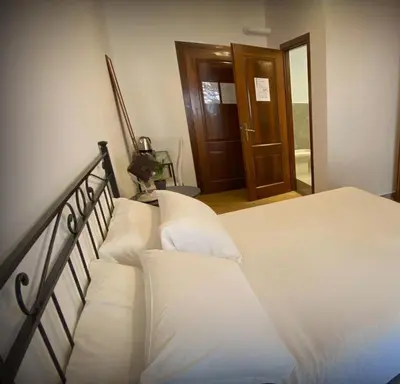 a bedroom with a bed with white sheets and pillows at MM Ma Maison in Rome